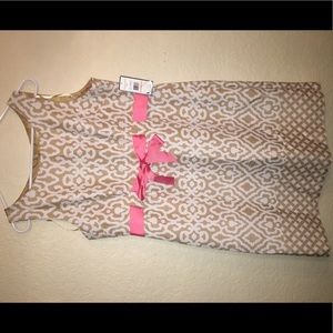 A white/ tan dress with pink bow tie in front.